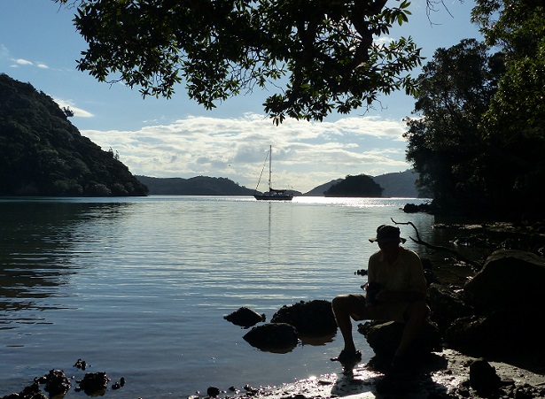 Randall cleaning his boots with Tregoning beyond in Kiwiriki Bay
